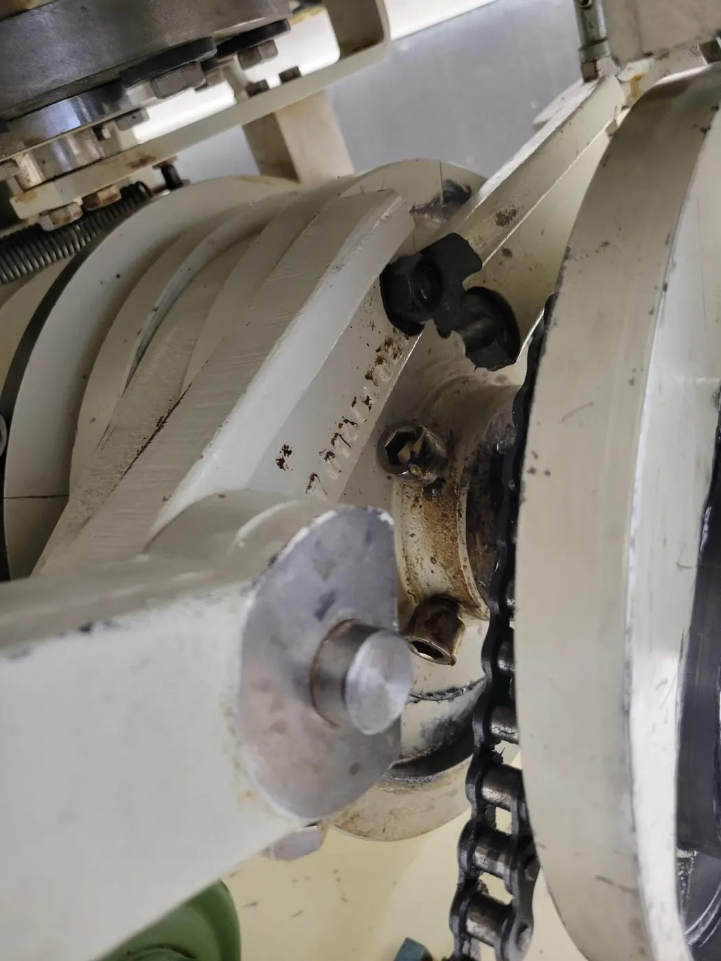 Stacked cam plates, follower arms and the roller drive chain of a capsule filling machine cam and arm assembly with the guards removed.